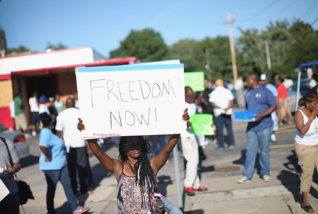 A Demonstrator protesting the shooting death of teenager Michael Brown holds up a sign on August 13, 2014 in Ferguson, Missouri. (Scott Olson / Getty Images)