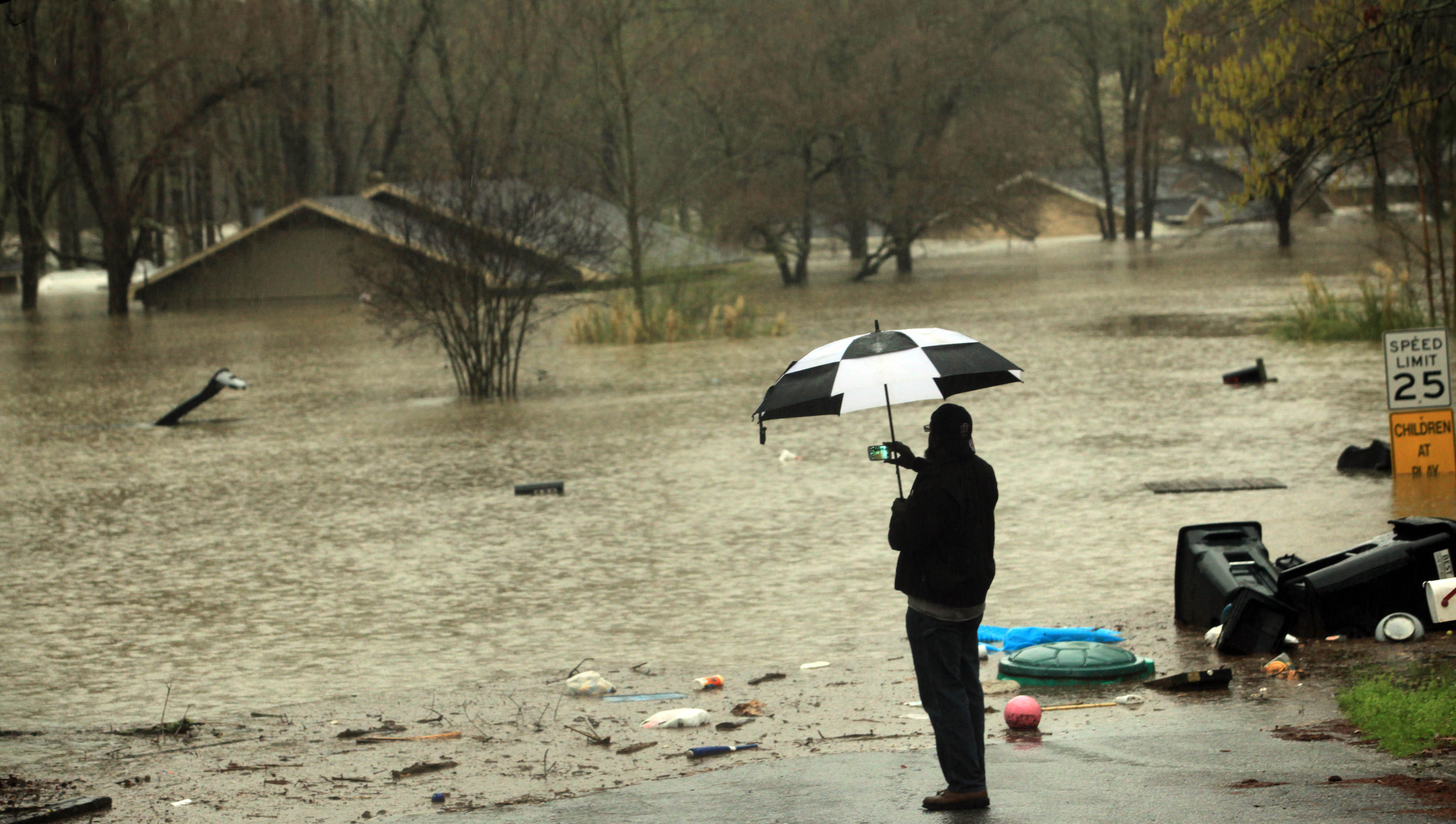 Haughton, La. resident David Stewart takes photos of flooded homes in the Tall Timbers subdivision Wednesday March 9, 2016. Severe thunderstorms have caused major flooding and closed all schools in the area. Several parishes in northwest Louisiana have declared a state of emergency over widespread flooding, and the National Guard is being sent in to help.  (AP Photo/Mike Silva)